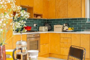 Close up of kitchen with flowers on the left and coffe and cups on top of the table