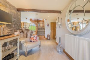 Image of a hallway with a mirror on the right and a chair on the left