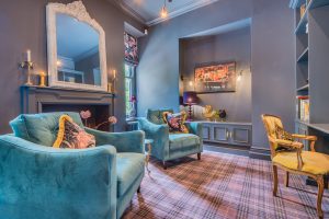 Image of a lounge with dark blue walls and two blue chairs