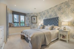 Image of a double bedroom with a bed and a window in the background