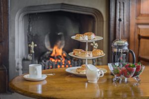 Image of an afternoon tea and the fireplace in the background