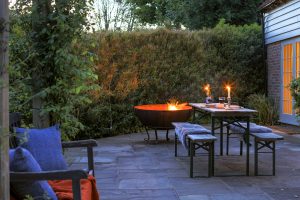 Outdoor phot with a lit firepit and candles on the table