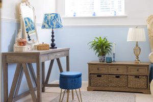 Image of the bedroom vanity unit with a blue seat and a chest to the right