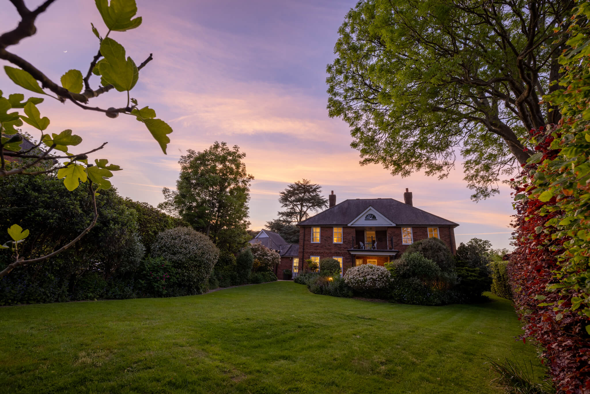 Twilight image of the rear garden with the house in the background