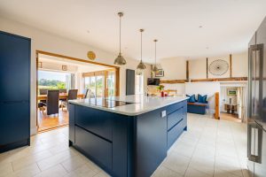 Image of an open paln kitchen with bifold doors to a conservatory with views over the rear garden